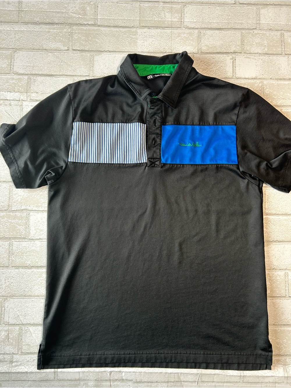 Travis Mathew Black Polo with Blue and White Stripe Chest Panels